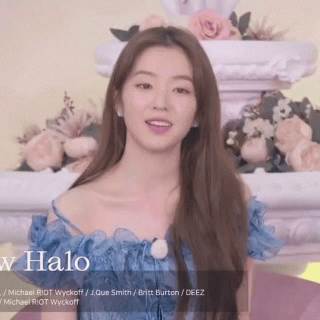 a woman in a blue dress is standing in front of flowers and the word halo on the bottom