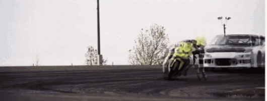 a man is riding a motorcycle in front of a car
