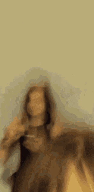 a blurry picture of a woman sitting on a bed .