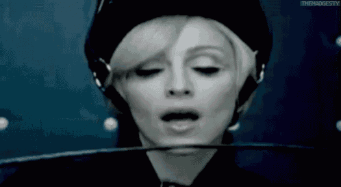 a close up of a woman wearing headphones and a helmet with the words thebadgesty written on the bottom