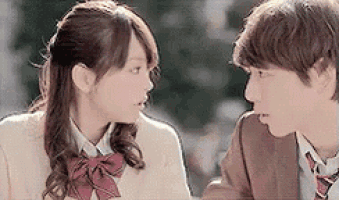 a boy and a girl are looking at each other and talking .
