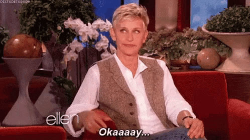 ellen degeneres is sitting on a red couch and says okay