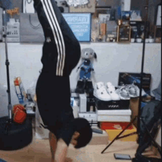 a man is doing a handstand in a room with a sign that says homelaw