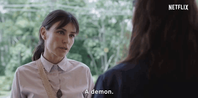 a woman talking to another woman with a netflix logo in the background
