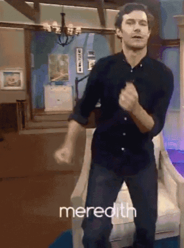 a man in a black shirt is dancing in a living room and the word meredith is on the bottom