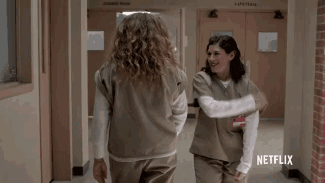 two women are dancing in a hallway with netflix written on the bottom right