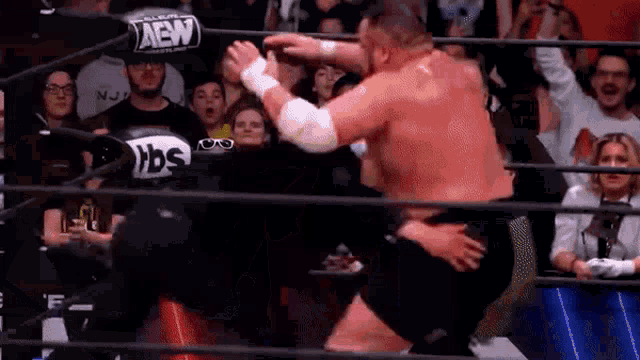 a man is wrestling another man in a wrestling ring .