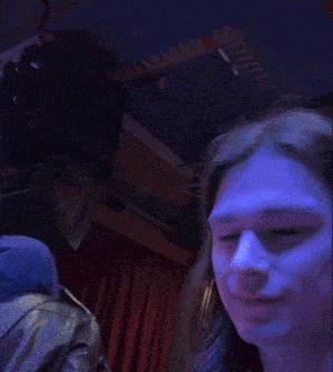 a close up of a woman 's face with a blue light behind her