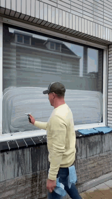 a man is cleaning a window with a cloth