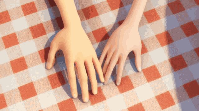 a couple of hands laying on a checkered tablecloth