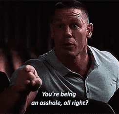 a man in a blue shirt is pointing at someone and saying `` you 're being an asshole , all right ? ''