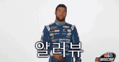a man in a blue nascar uniform is giving a peace sign