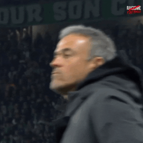 a man with his eyes closed stands in front of a sign that says " your son "