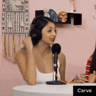 a woman wearing headphones is sitting in front of a microphone with the word carve above her
