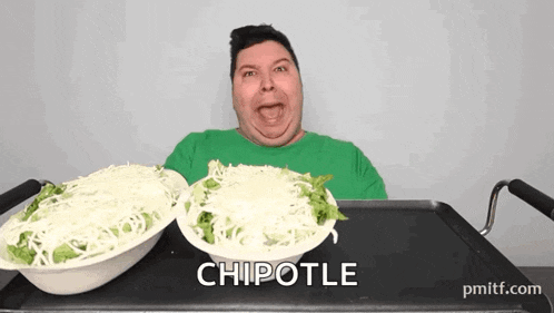 a man in a green shirt is eating a chipotle