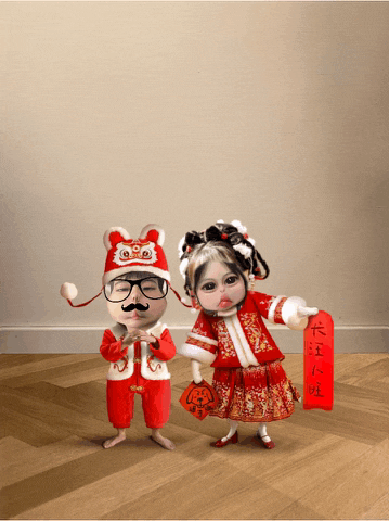 a boy and a girl are standing next to each other and the girl is holding a red sign with chinese writing