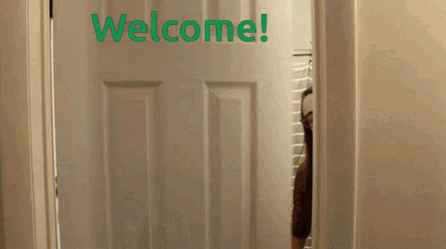 a woman peeking out of a door that says welcome on it