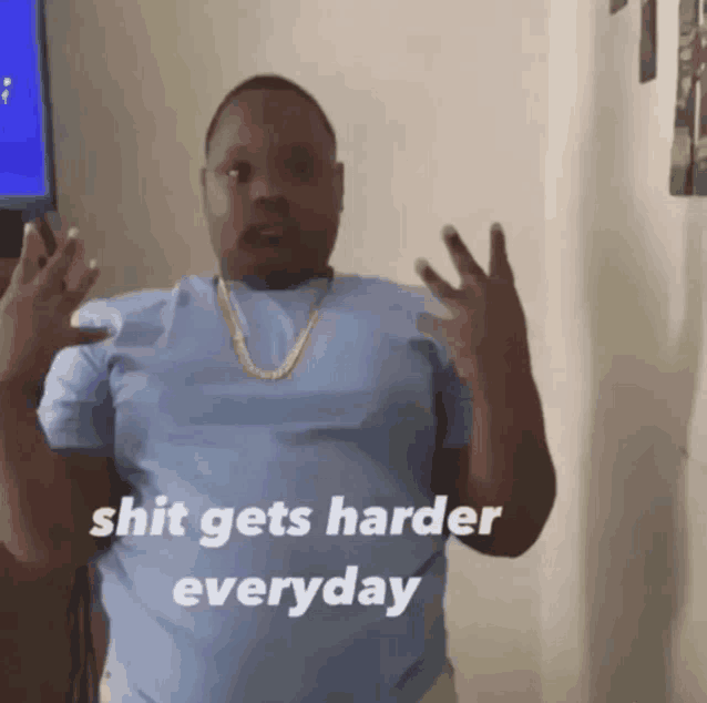 a man in a blue shirt with the words shit gets harder everyday below him