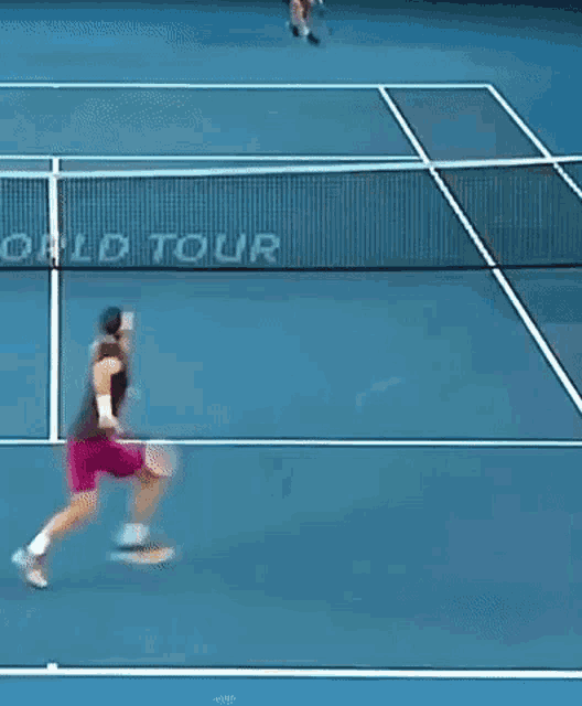 a tennis player on a blue court with the word world tour written on the net