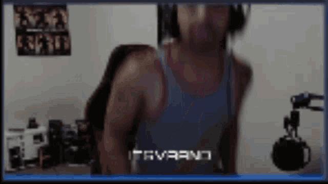 a man wearing headphones and a tank top is standing in front of a microphone ..