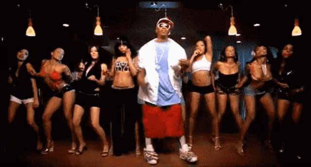 a group of women are dancing with a man wearing a shirt that says ' i love nyc '