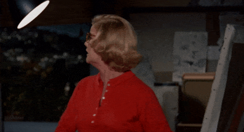 a woman wearing glasses and a red shirt is crying