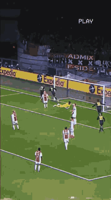 a soccer game is being played on a field with expedia advertisements on the sidelines