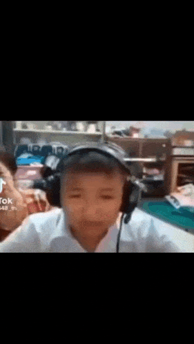 a young boy wearing headphones is sitting in a room .