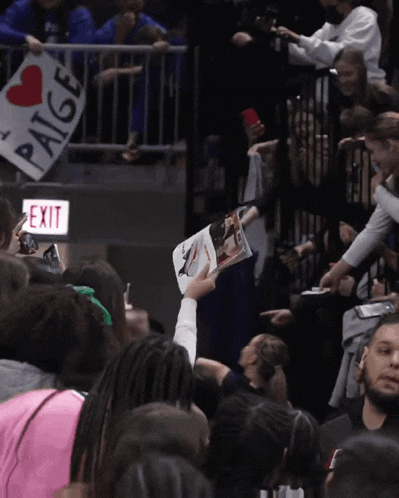 a sign that says paige on it in a crowd