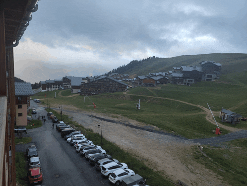 a row of cars are parked in front of a mountain