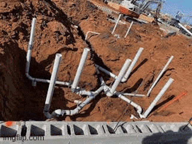 a bunch of pipes are laying in the dirt on the ground