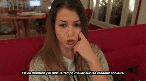a woman sitting on a red couch with a caption that says en ce moment j'ai plus