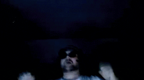 a man with his arms in the air wearing sunglasses and a hat