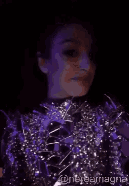 a woman in a purple and silver outfit is making a face .