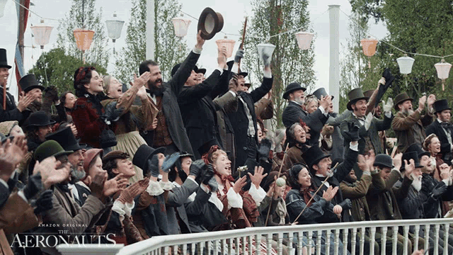 a crowd of people are applauding in front of a sign that says aeronauts