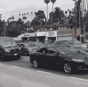 several cars are driving down a street in front of a building that says ' bloom '
