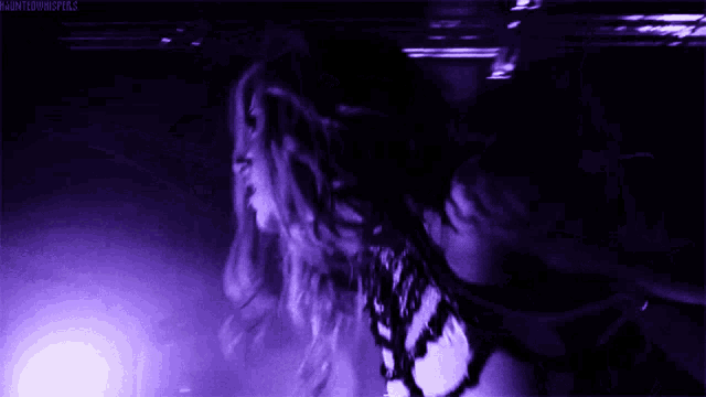 a woman is dancing in a dark room with a purple light behind her and the words hauntedmasters on the bottom