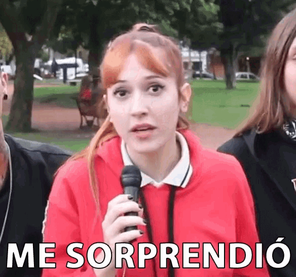 a woman in a red sweatshirt is holding a microphone and the words me sorprendio are above her