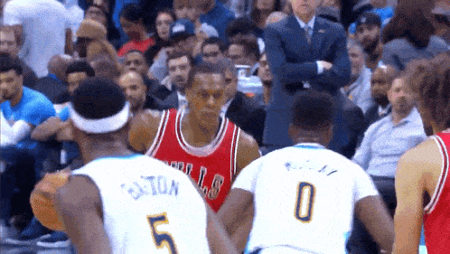 a basketball player wearing a bulls jersey is talking to another player