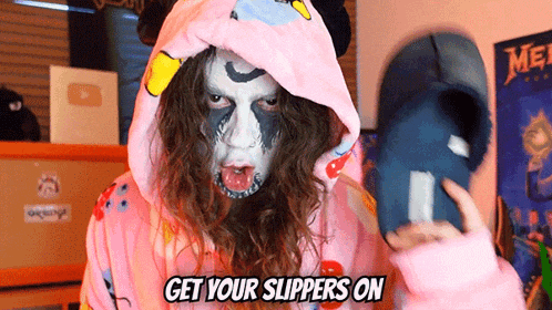 a person wearing a pink hoodie with the words get your slippers on written on it