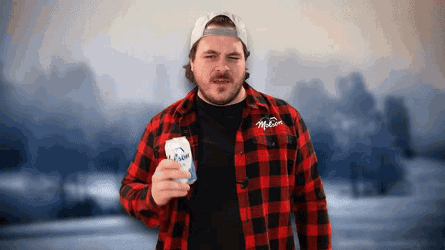 a man in a plaid shirt holds up a can of mccormick