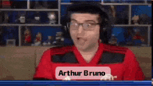 a man wearing headphones and a red shirt named arthur bruno