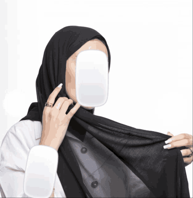 a woman wearing a black hijab and a white ring