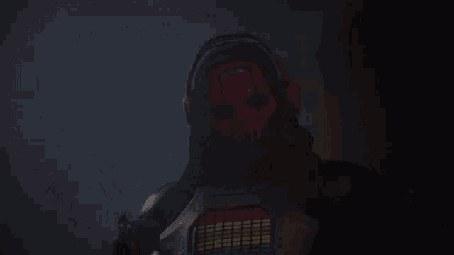 a person with a red mask on their face is wearing a black hooded jacket