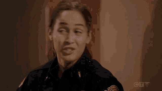 a woman in a firefighter 's uniform is smiling .