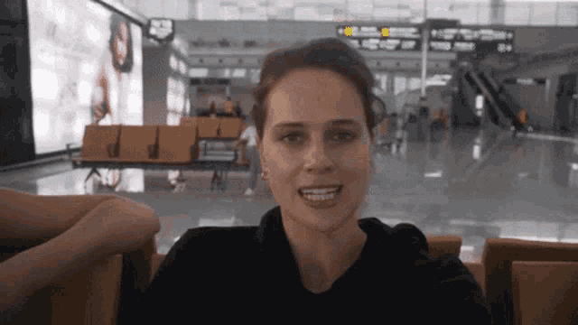 a woman is sitting in a waiting area with a sign that says ' a ' on it