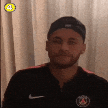 a man wearing a hat and a shirt with the number 4 on it