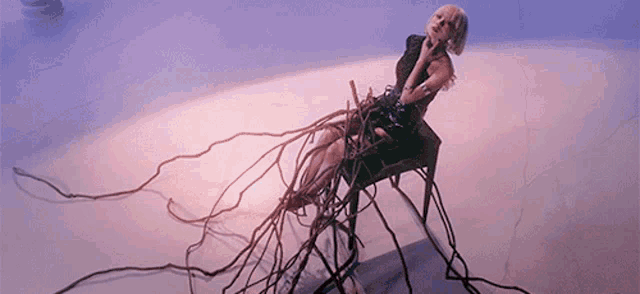 a woman is sitting on a chair with a bunch of wires around her legs .
