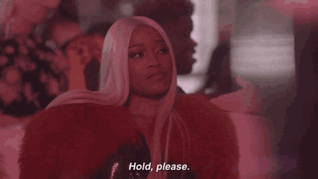 a woman in a red fur coat says " hold please "