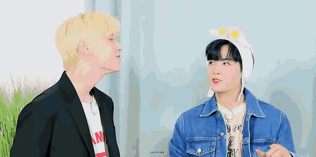 two young men are standing next to each other and looking at each other .